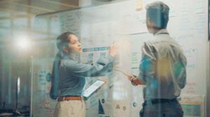 Two people working on a white board